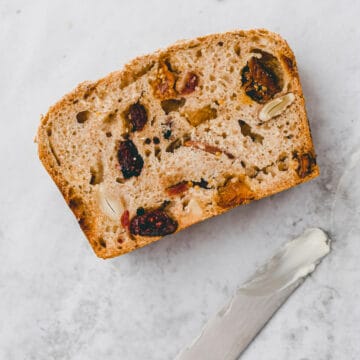 a slice of fruit bread next to a knife