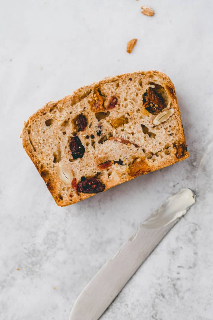 a slice of fruit bread next to a knife