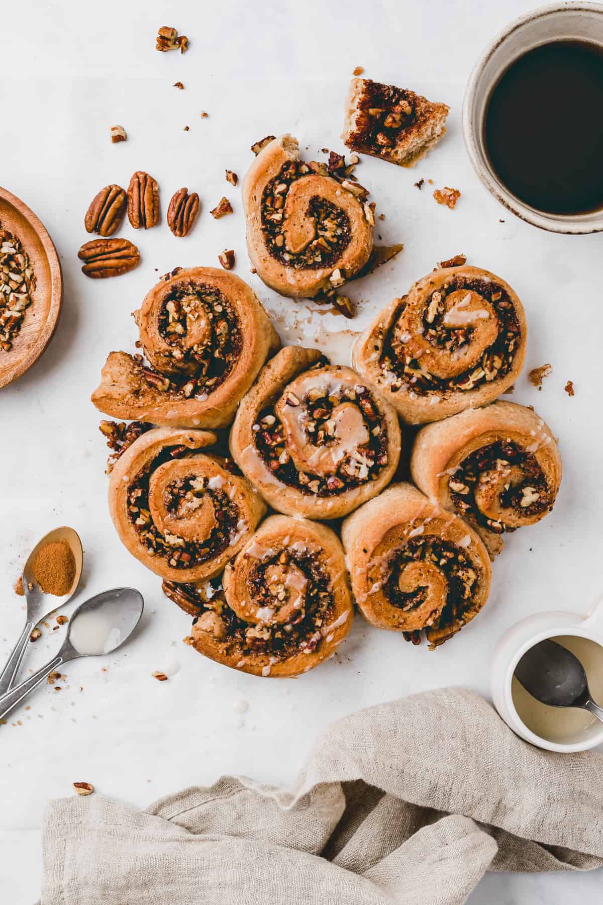 pecan cinnamon rolls next to a cup of coffee