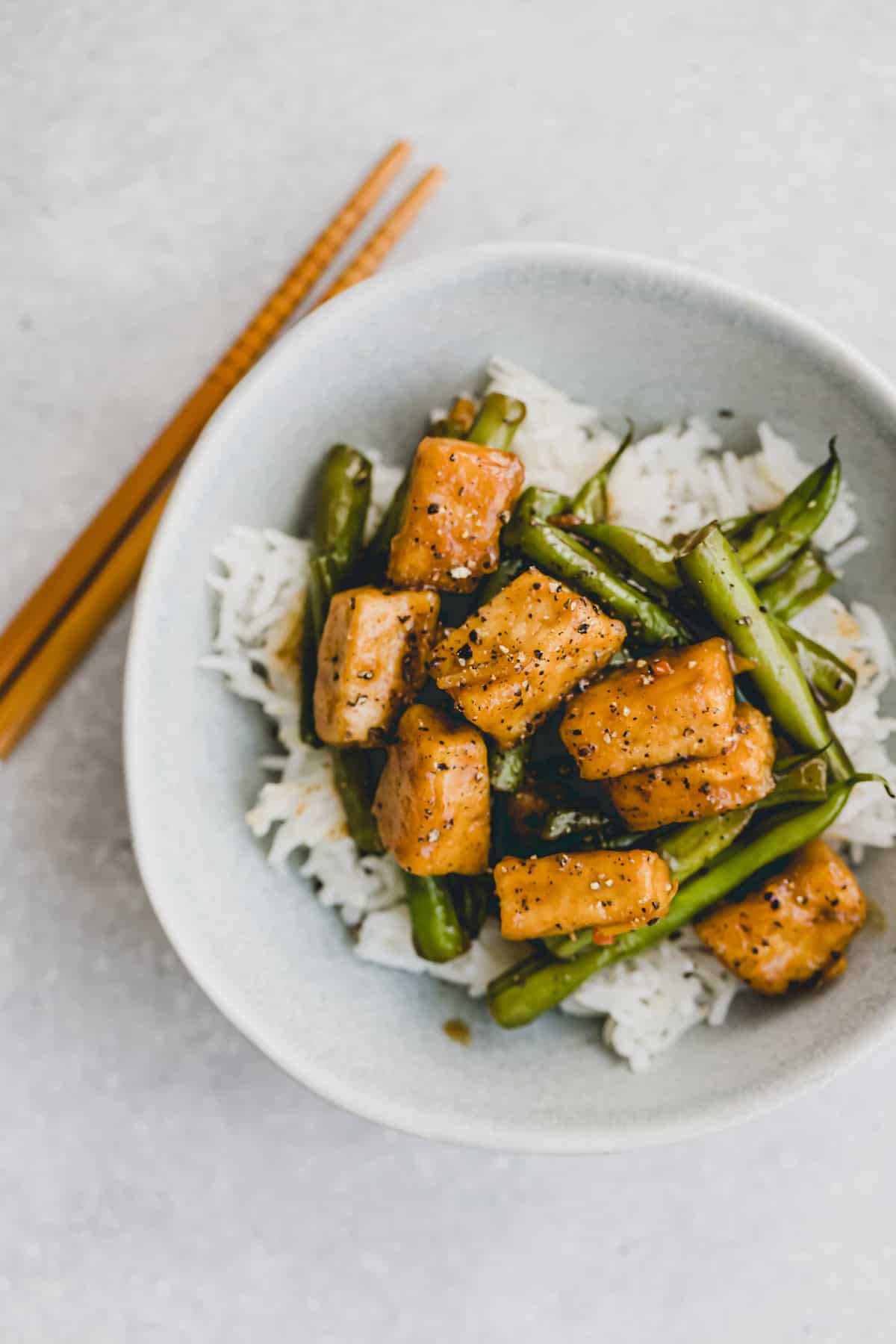 tofu green bean stir fry over rice in a small bowl