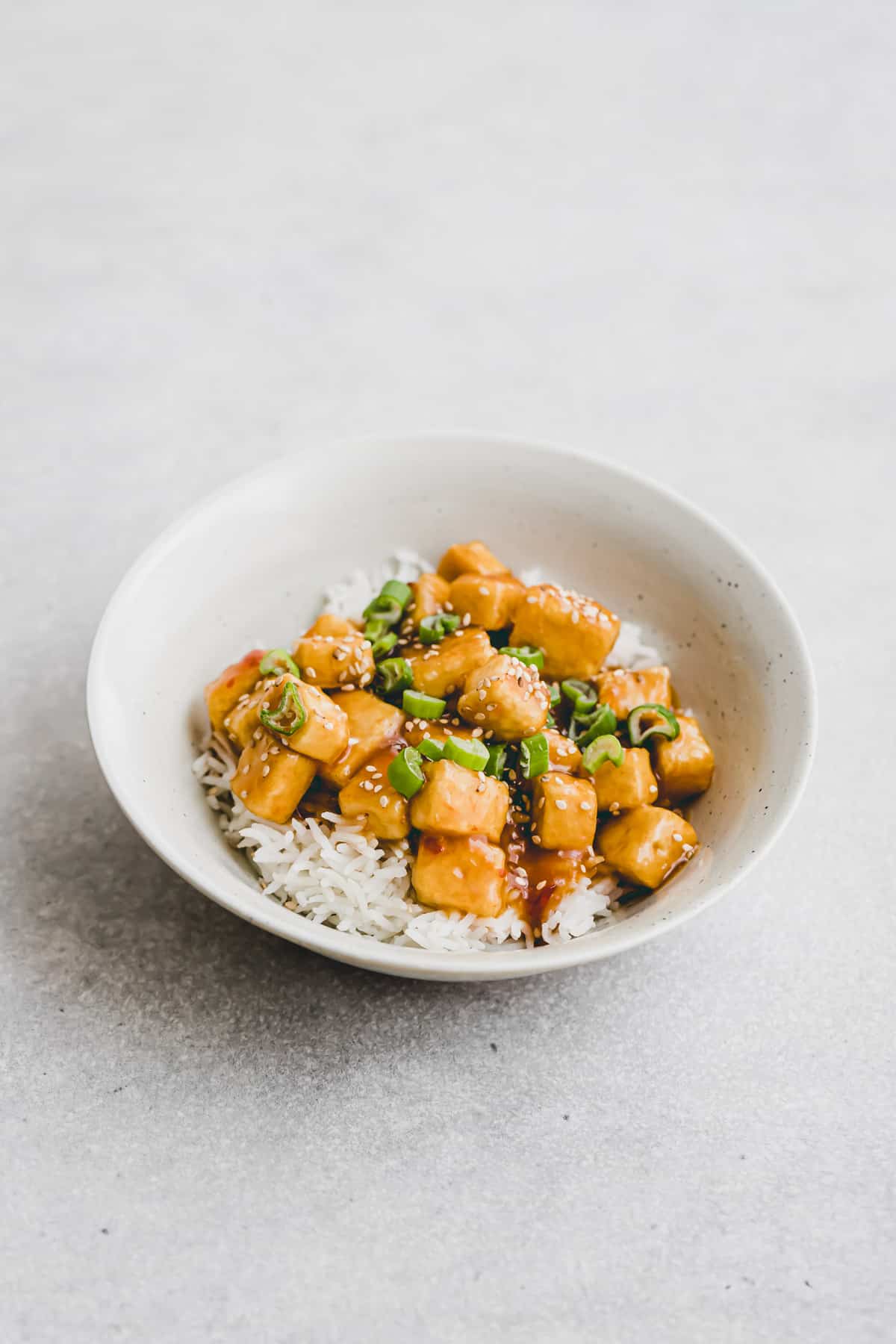 eine schüssel orangen tofu mit reis