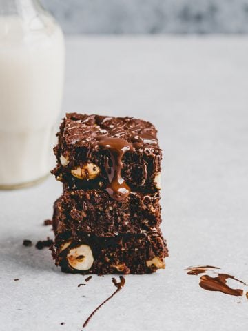 paleo brownies stacked next to a bottle dairy-free milk