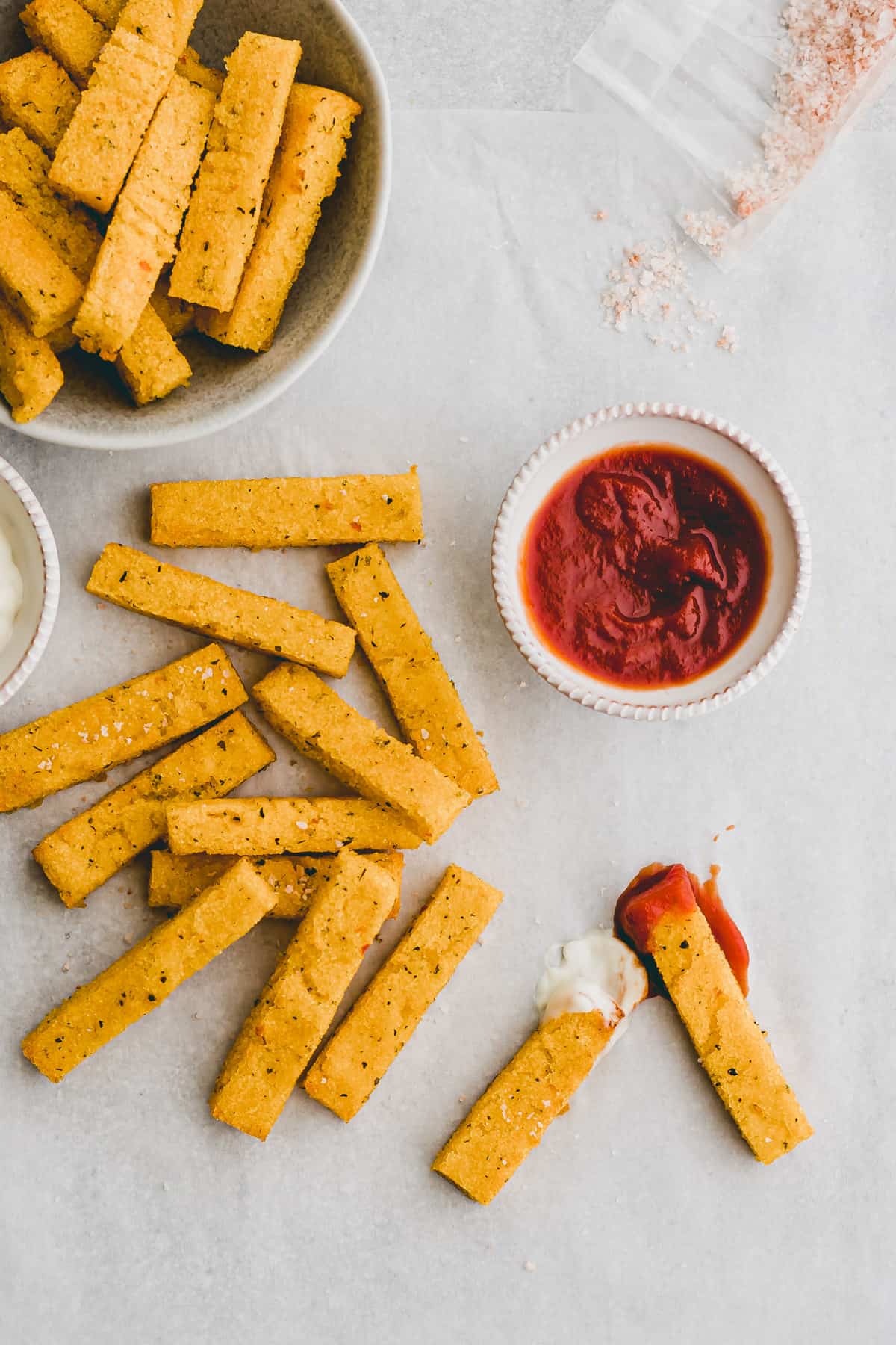 baked polenta fries next to a small bowl with ketchup