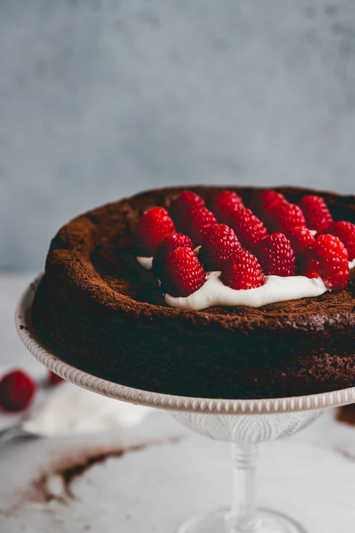 dairy-free flourless chocolate cake on a cake stand