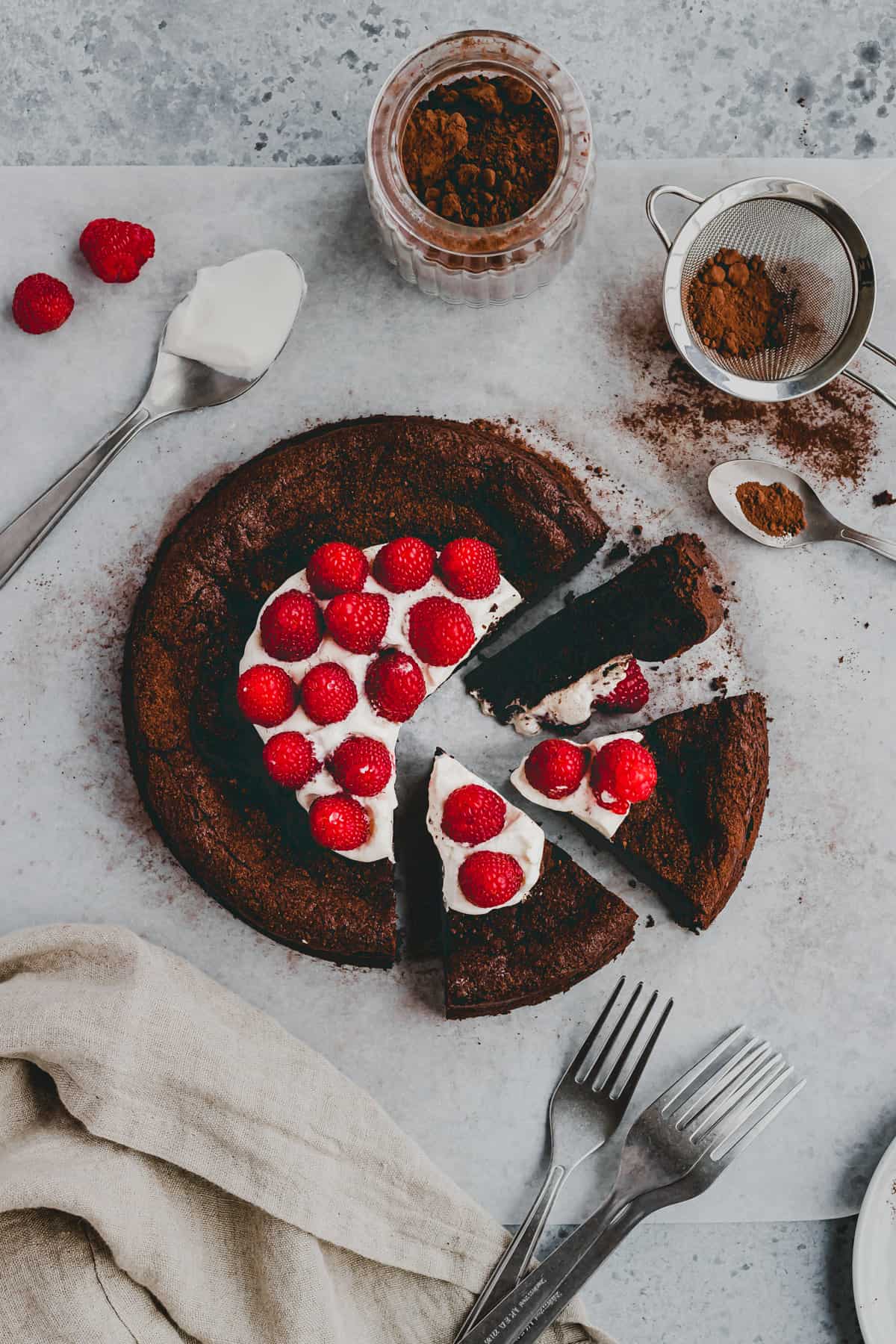 gesunder glutenfreier schokokuchen in stücken geschnitten mit himbeeren