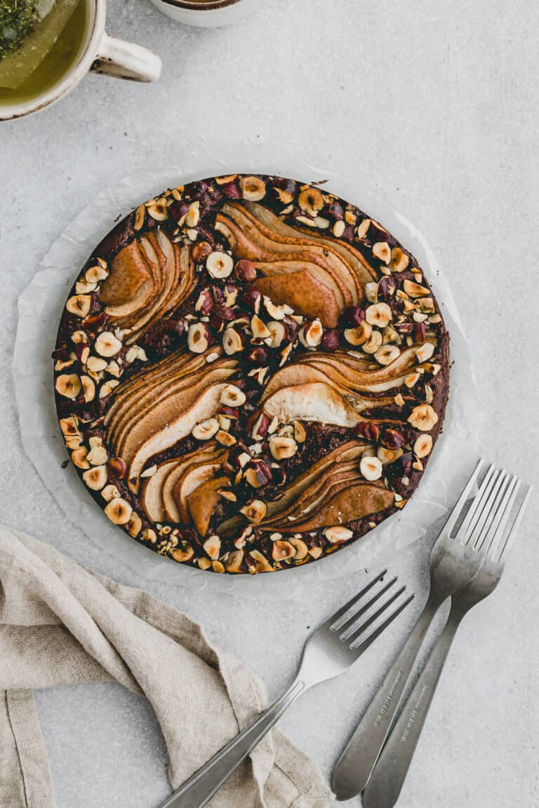 schokokuchen mit birnen und olivenöl neben einer tasse tee