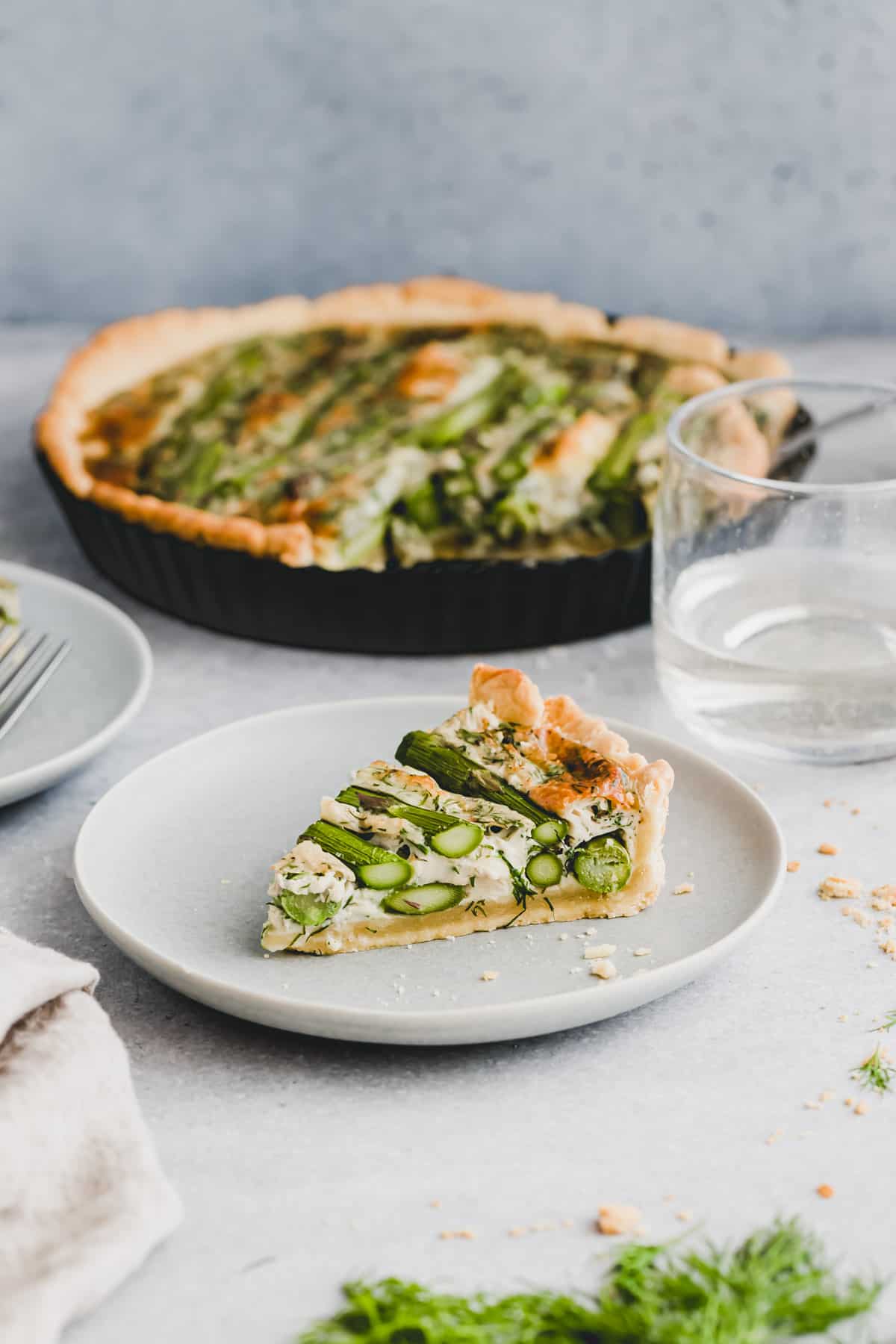 a slice of green asparagus quiche on a blue plate