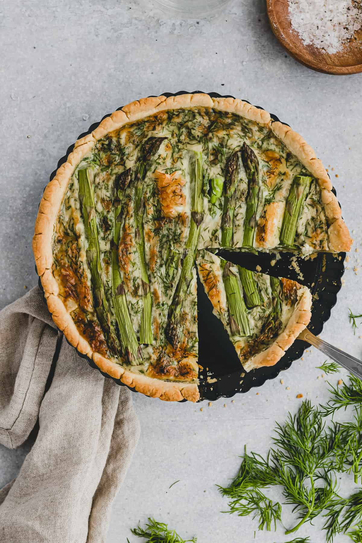 sliced quiche with green asparagus in a quiche pan