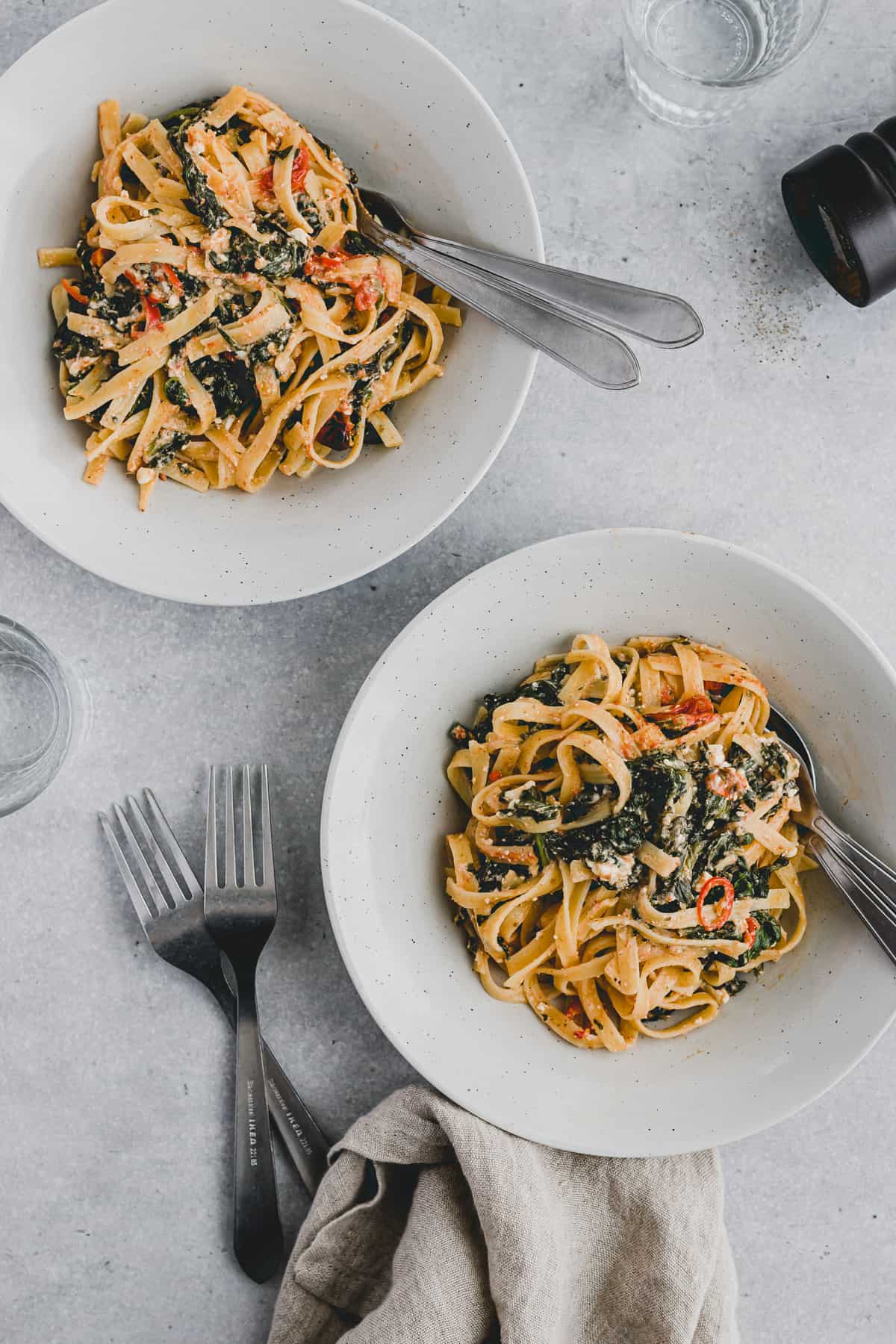 two dished with baked feta spinach pasta