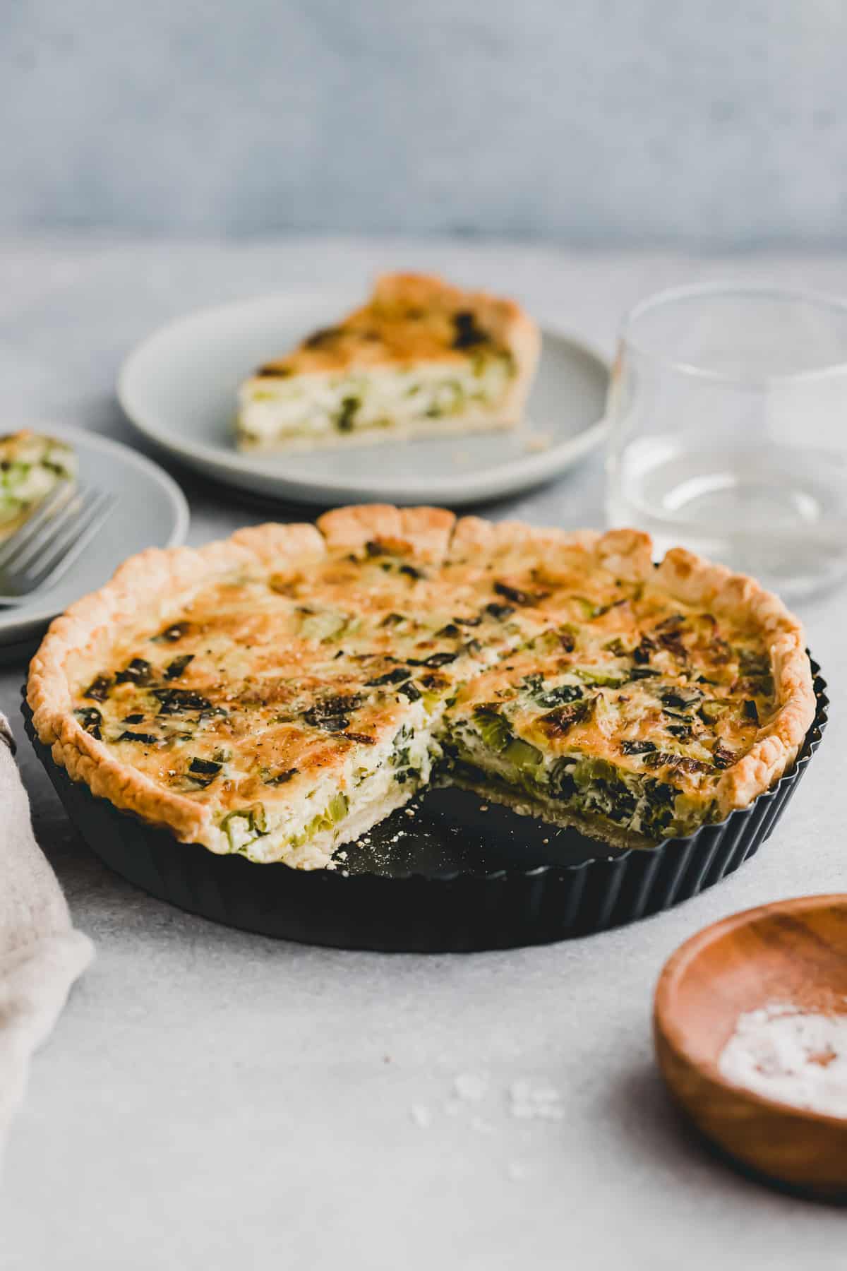 side shot of sliced leek quiche in a tart pan