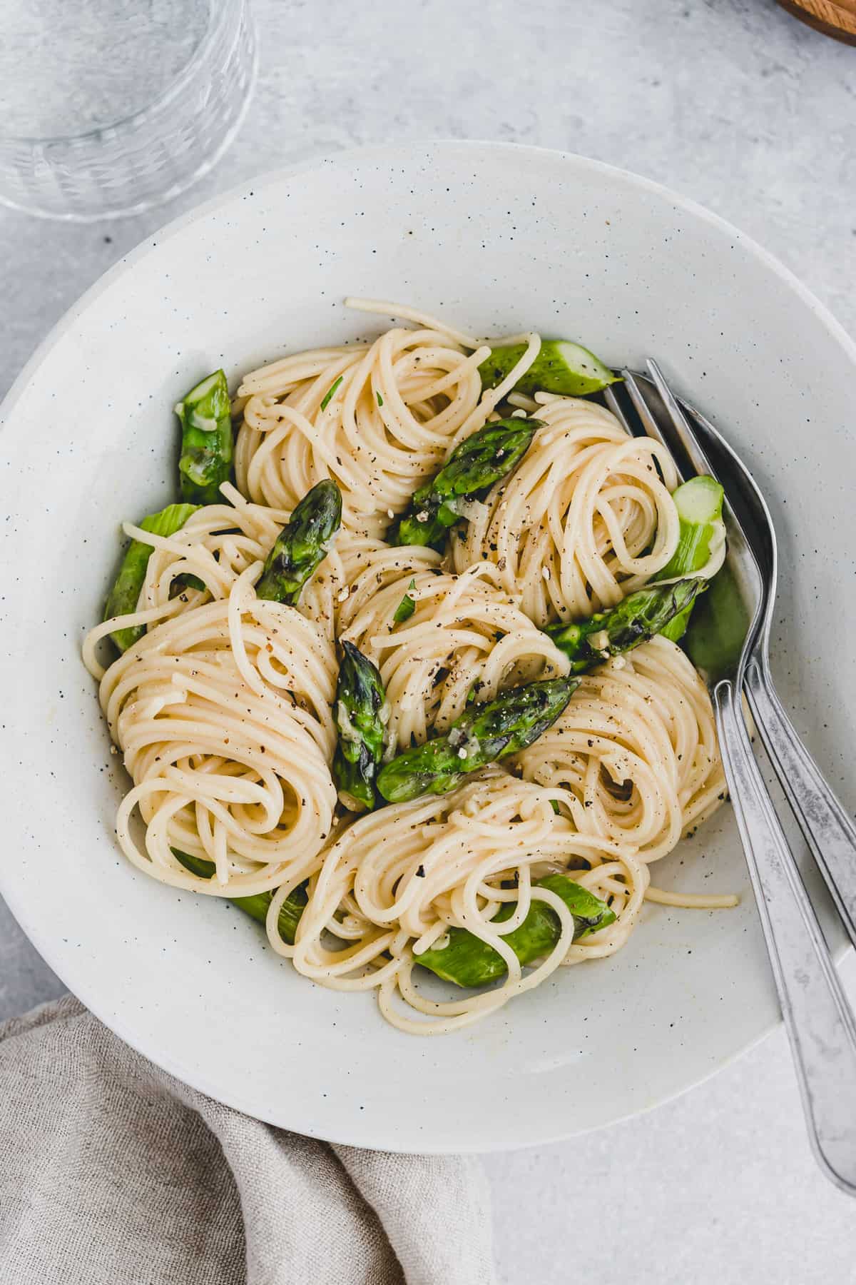 vegetarische spaghetti carbonara mit grünem spargel in einem pastateller
