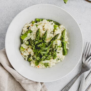 a bowl with risotto, asparagus, and mint