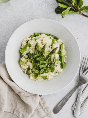 a bowl with risotto, asparagus, and mint