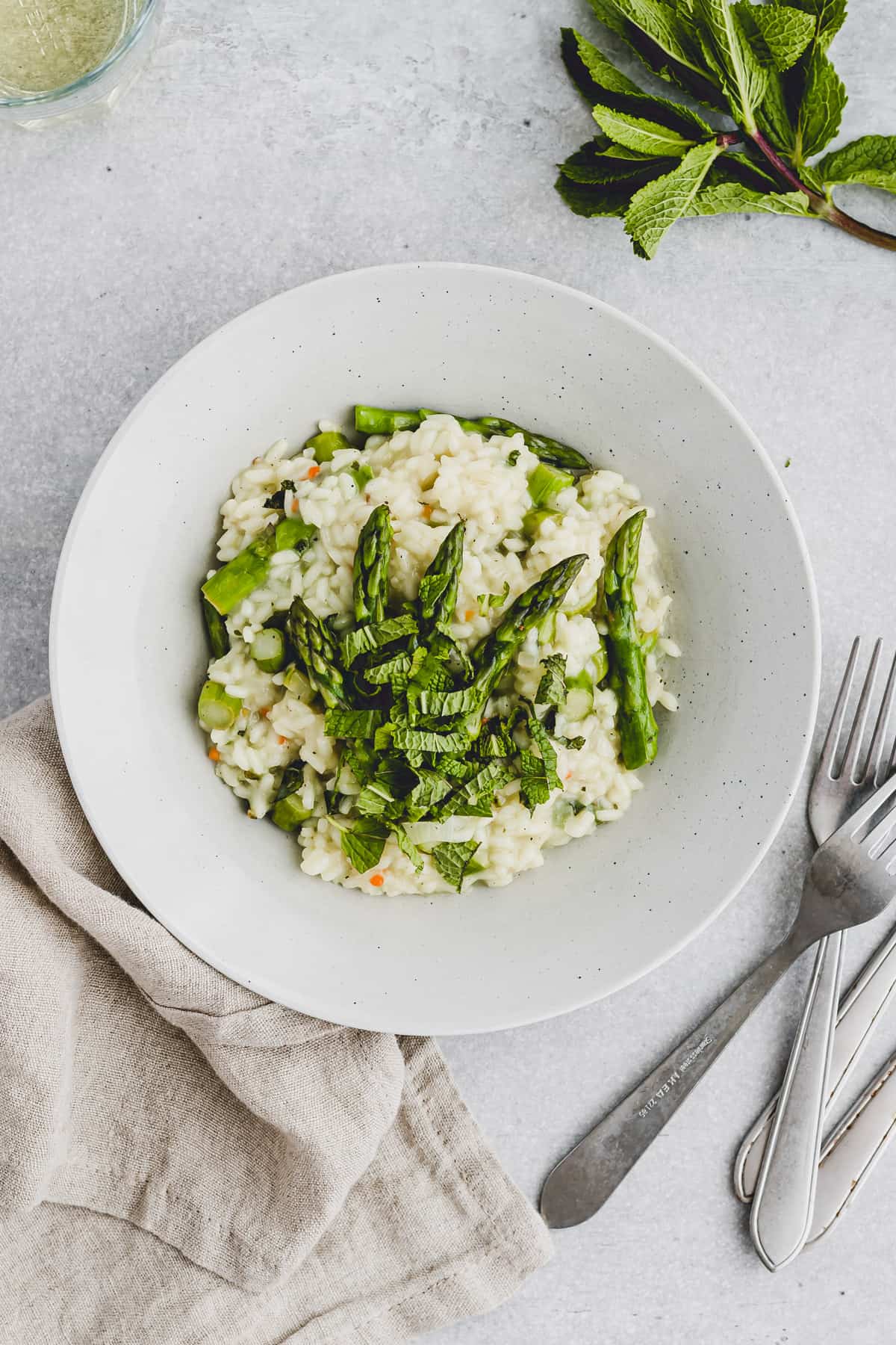 a bowl with risotto, asparagus, and mint