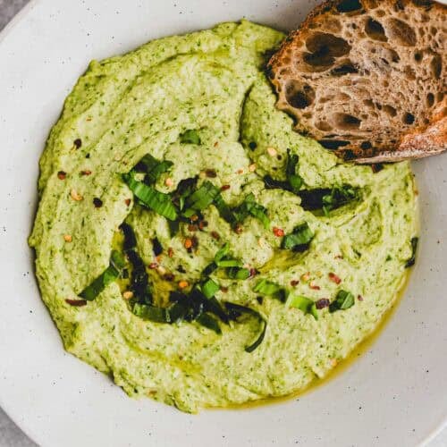 bärlauch hummus in einem tiefen teller mit einem stück brot