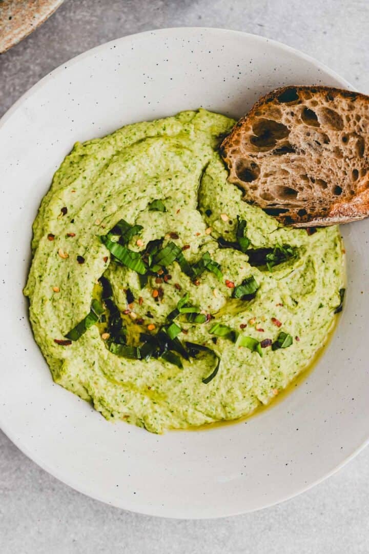 bärlauch hummus in einem tiefen teller mit einem stück brot