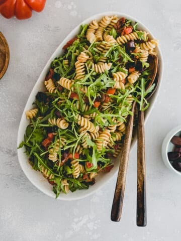 Mediterranean Pasta Salad next to a tomato and olives