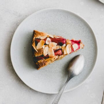 a slice of rhubarb almond cake on a blue plate