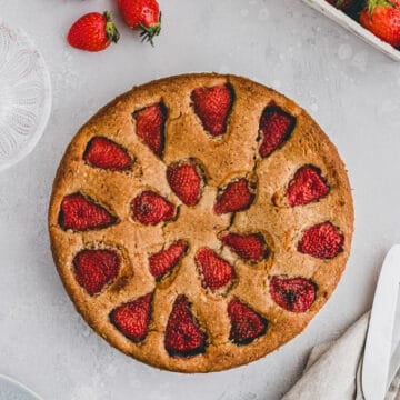 strawberry almond cake next to a few strawberries