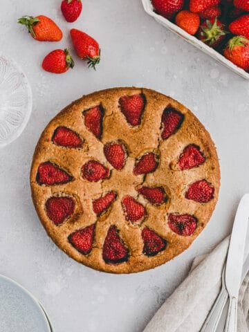 strawberry almond cake next to a few strawberries