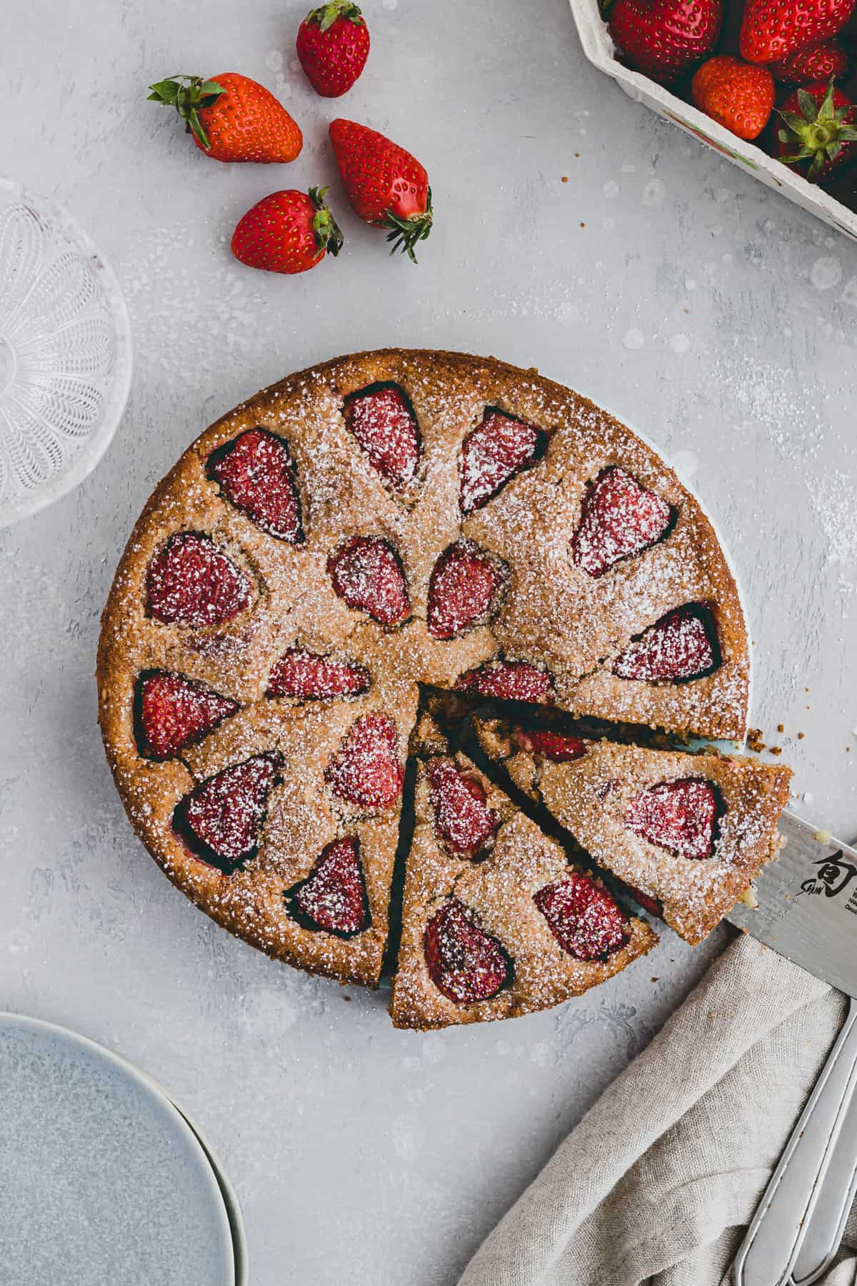 strawberry almond cake with powdered sugar on top