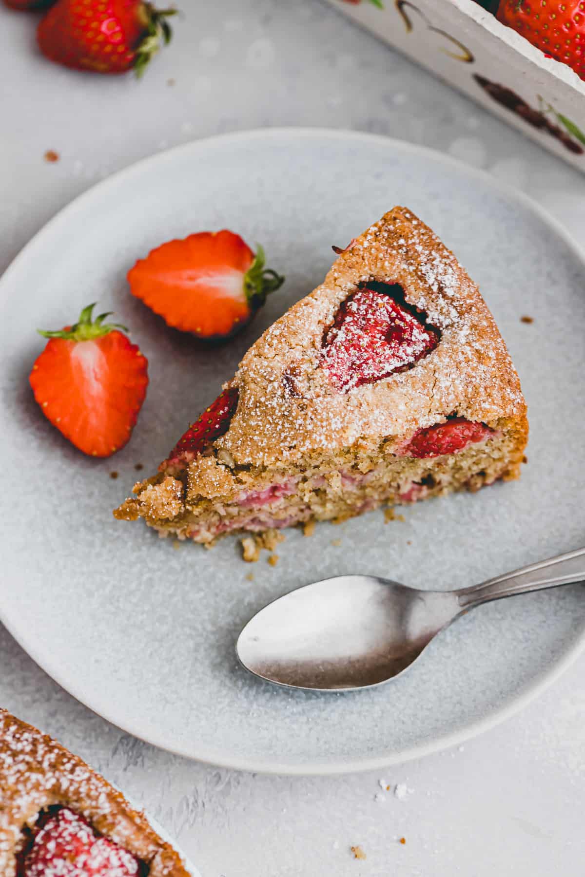 a slice strawberry almond cake on a blue plate