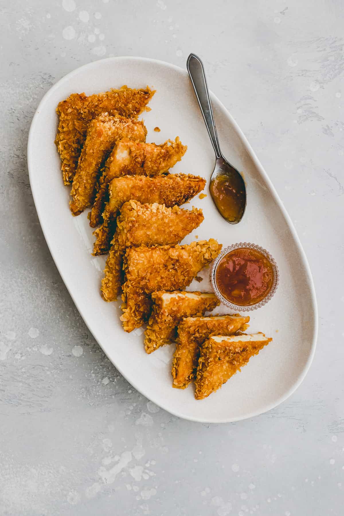 crispy tofu with cornflakes crust on a white plate