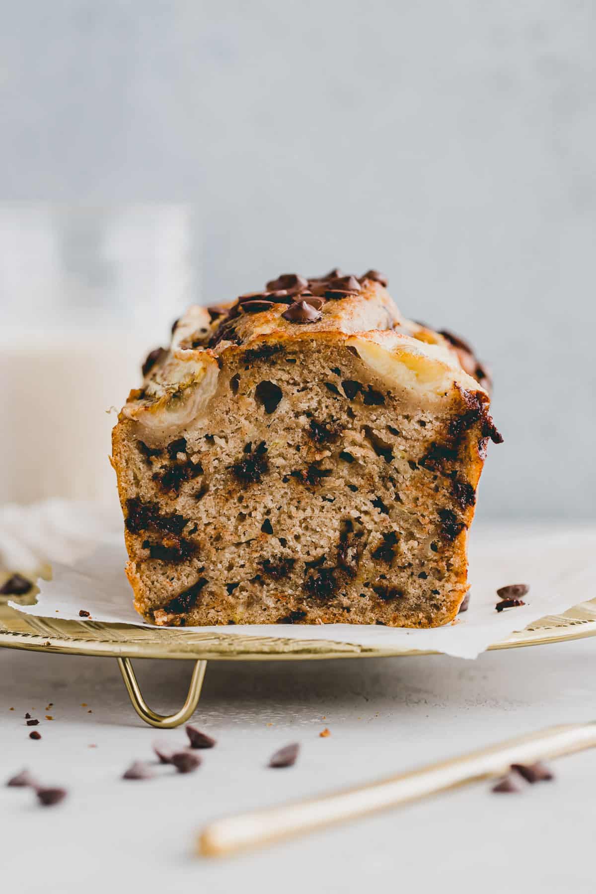 angeschnittenes veganes bananenbrot auf einem goldigen gitter