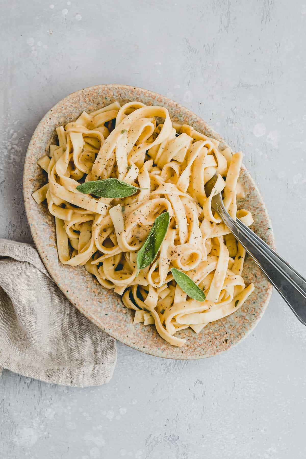 vegan pumpkin pasta alfredo style with sage on a plate