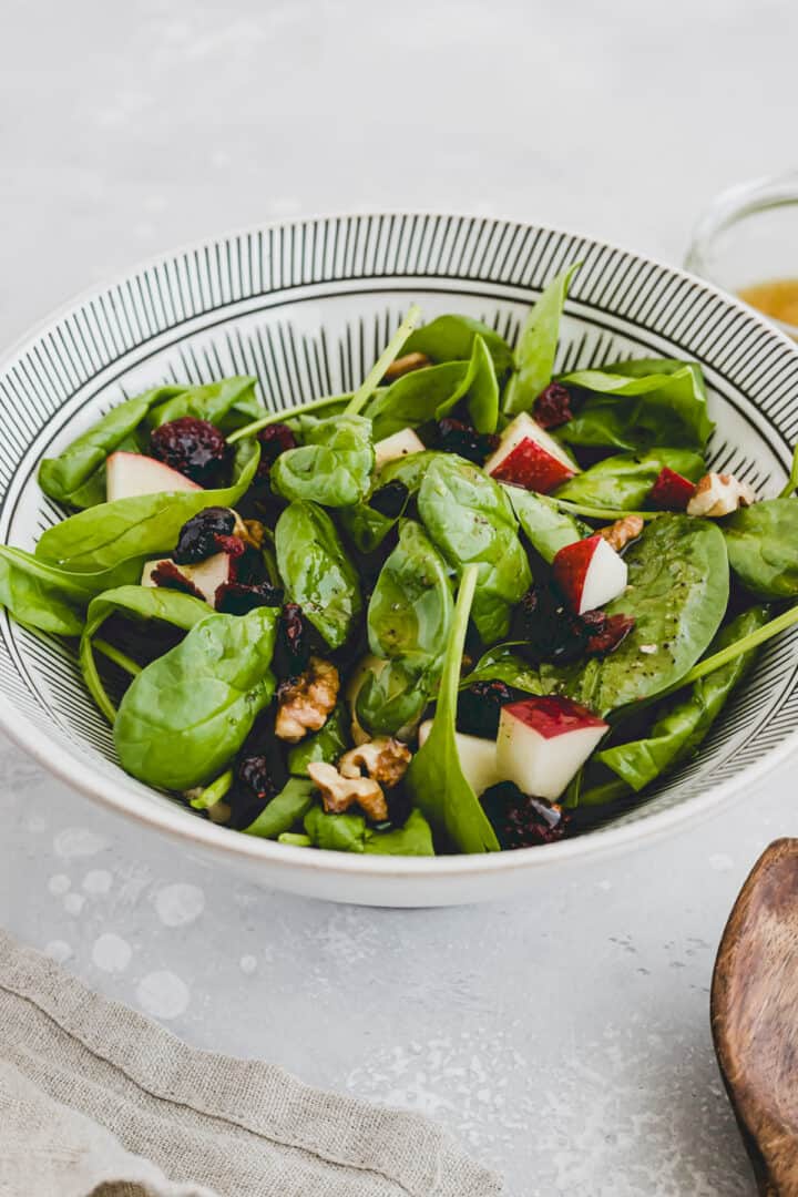 spinach cranberry salad with apple in a bowl