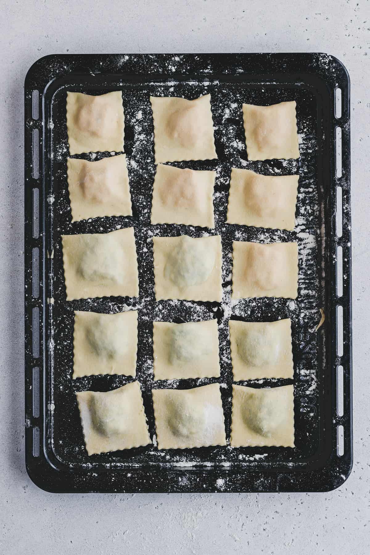 fresh ravioli on a floured baking tray