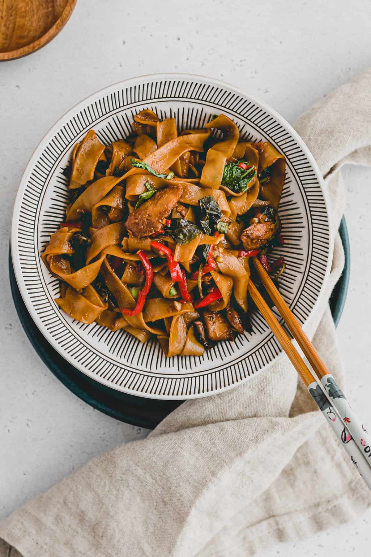 vegan thai drunken noodles in a bowl with chopsticks