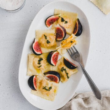 buttternut squash ravioli on a plate with fresh figs