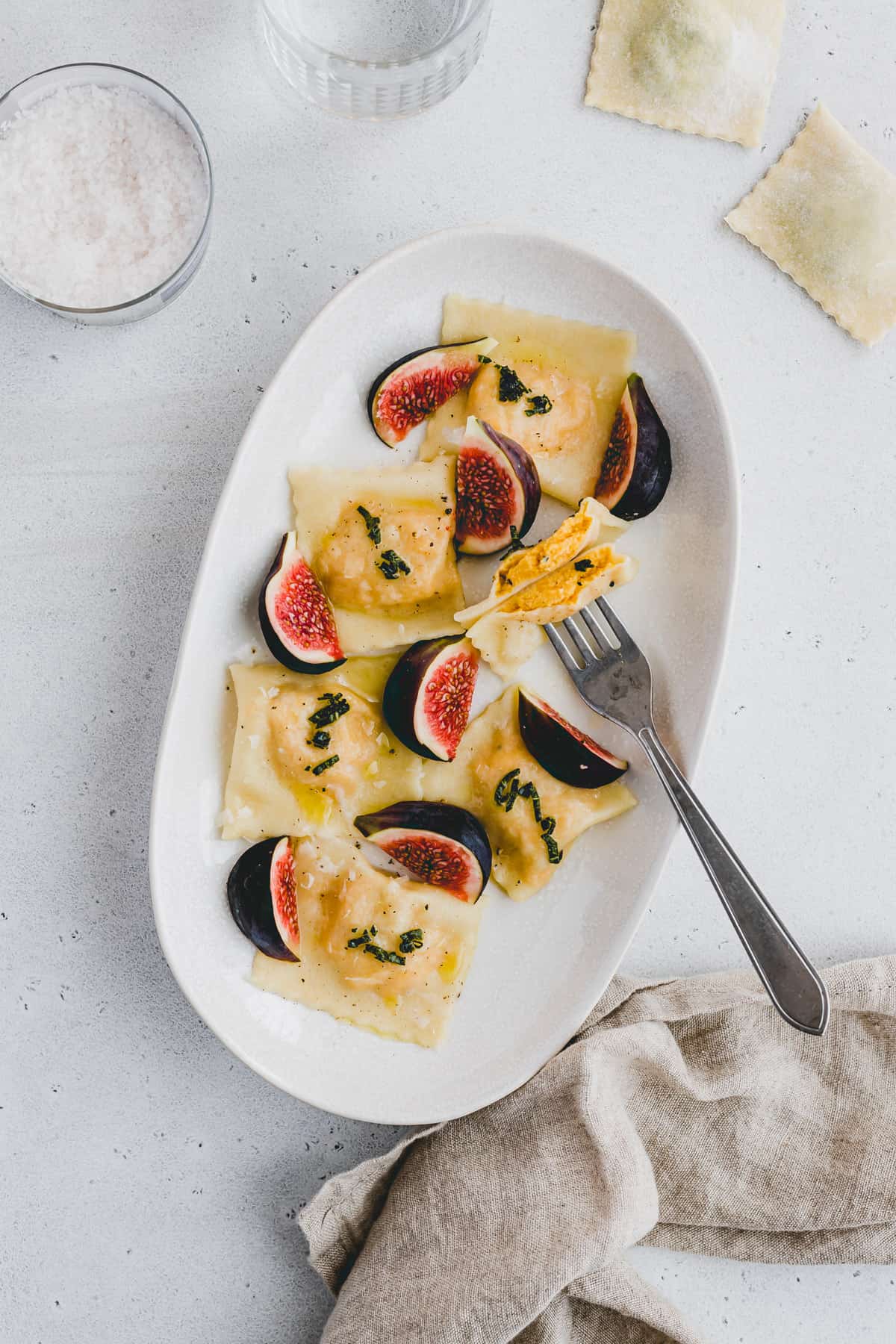 buttternut squash ravioli on a plate with fresh figs