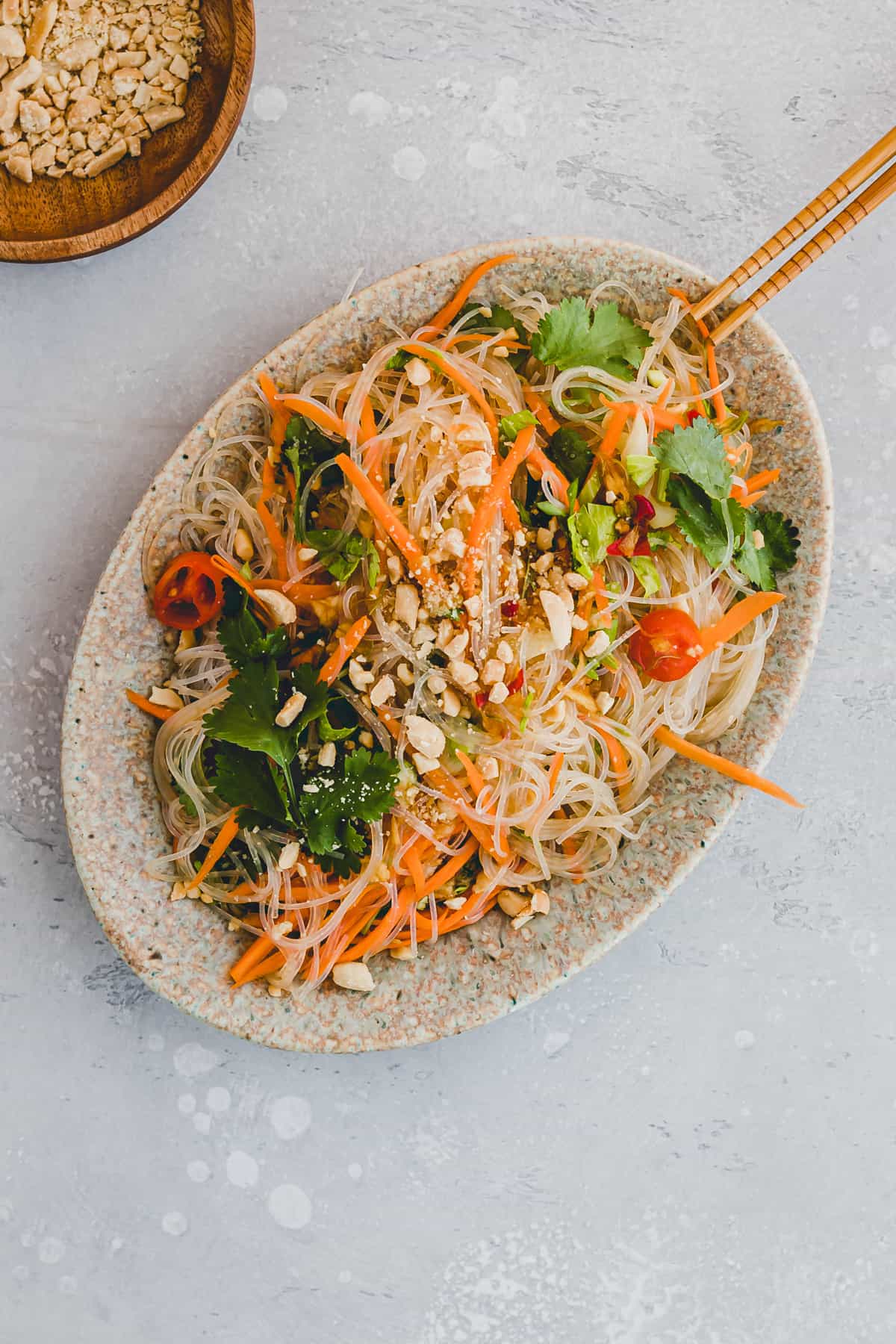 thai glass noodle salad next to a bowl of peanuts