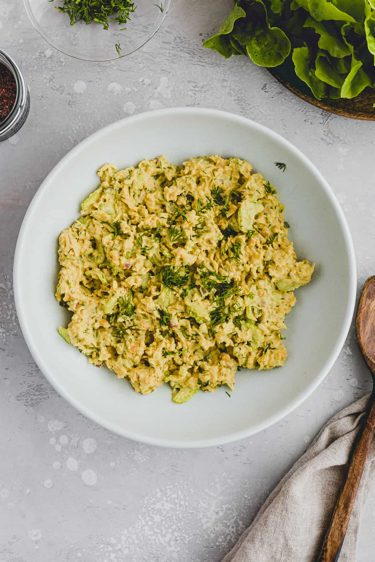 Vegan Chickpea Egg Salad in a bowl with a wooden spoon