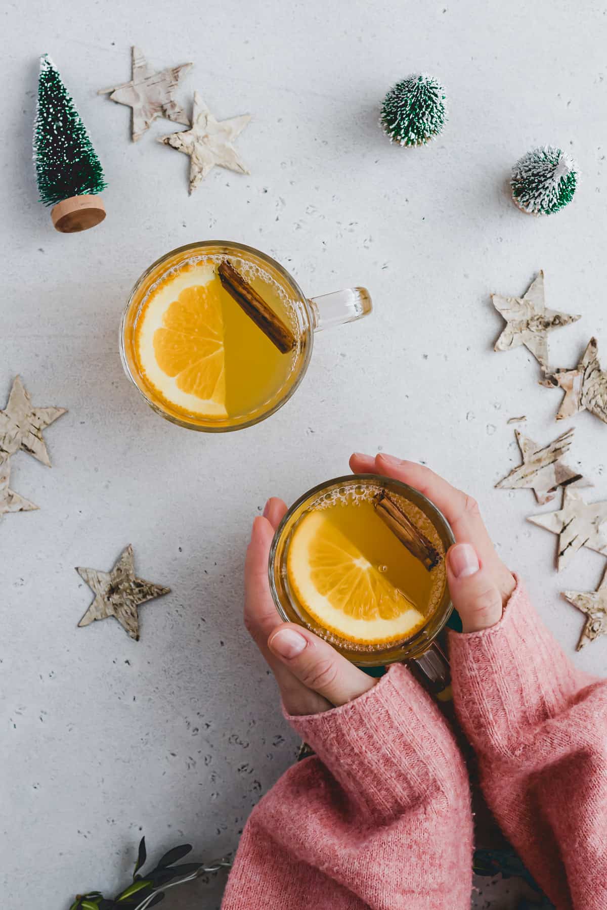 zwei hände halten ein glas weißer Glühwein