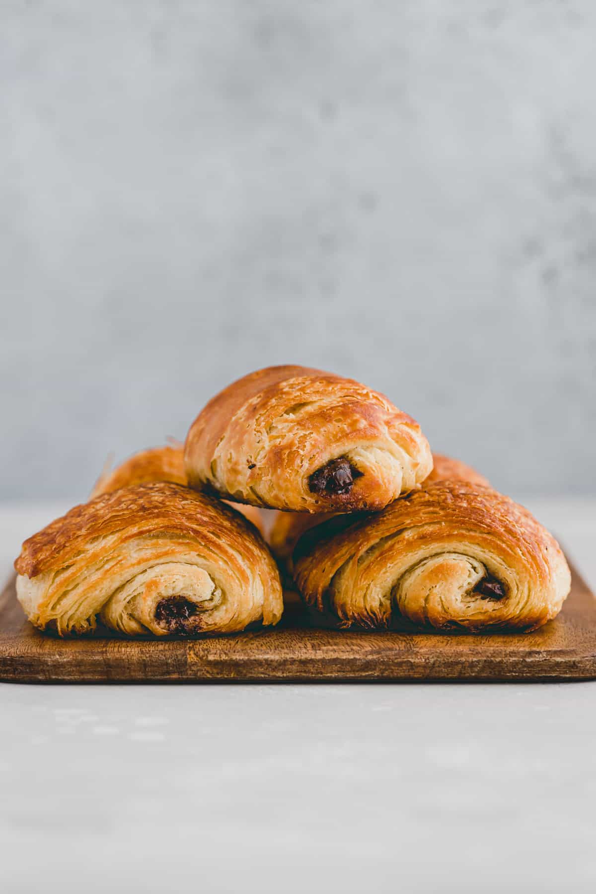 three pain au chocolat on a wooden board