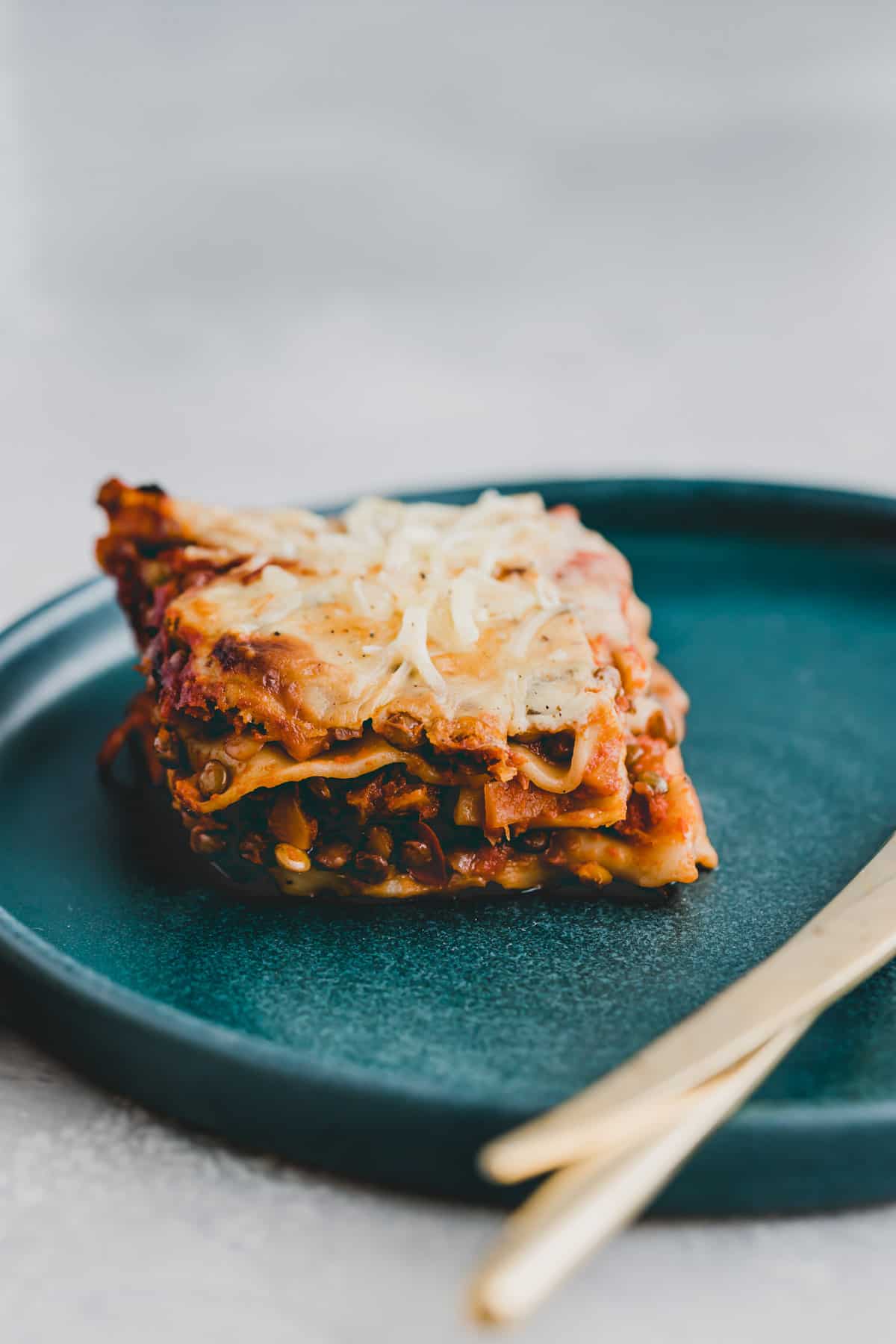 ein stück vegane lasagne mit linsen und bechamelsauce