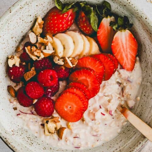 birchermüesli mit joghurt und frischen früchten in einer schüssel serviert
