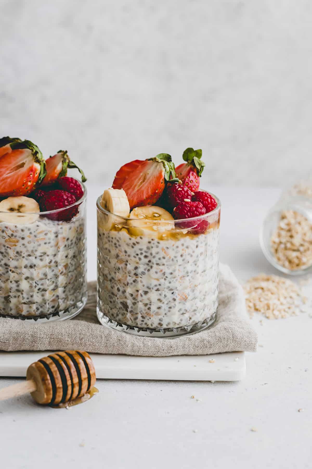 overnight oats in zwei gläsern mit frischem obst dekoriert