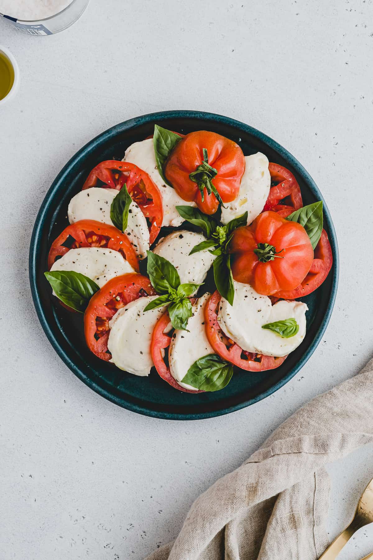 veganer tomate mozzarella salat auf einem blauen teller