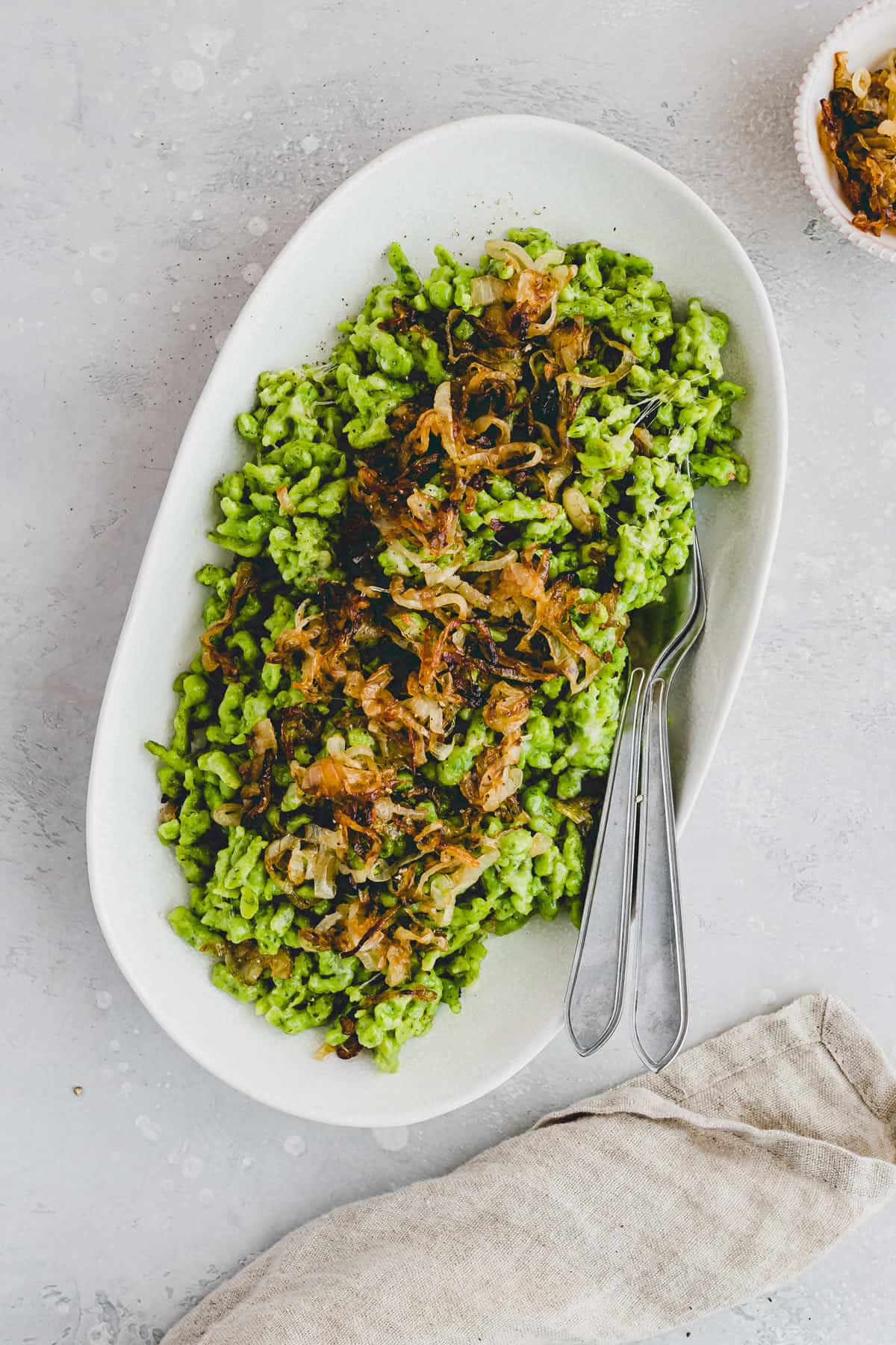 bärlauch käsespätzle mit röstzwiebeln auf einer platte serviert