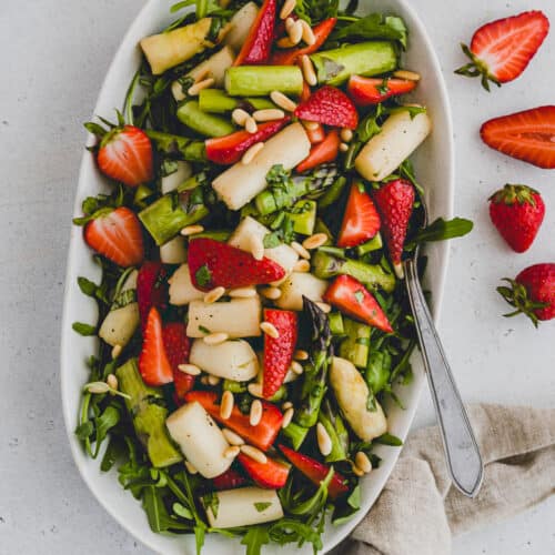 spargelsalat mit erdbeeren und rucola auf einer servierplatte