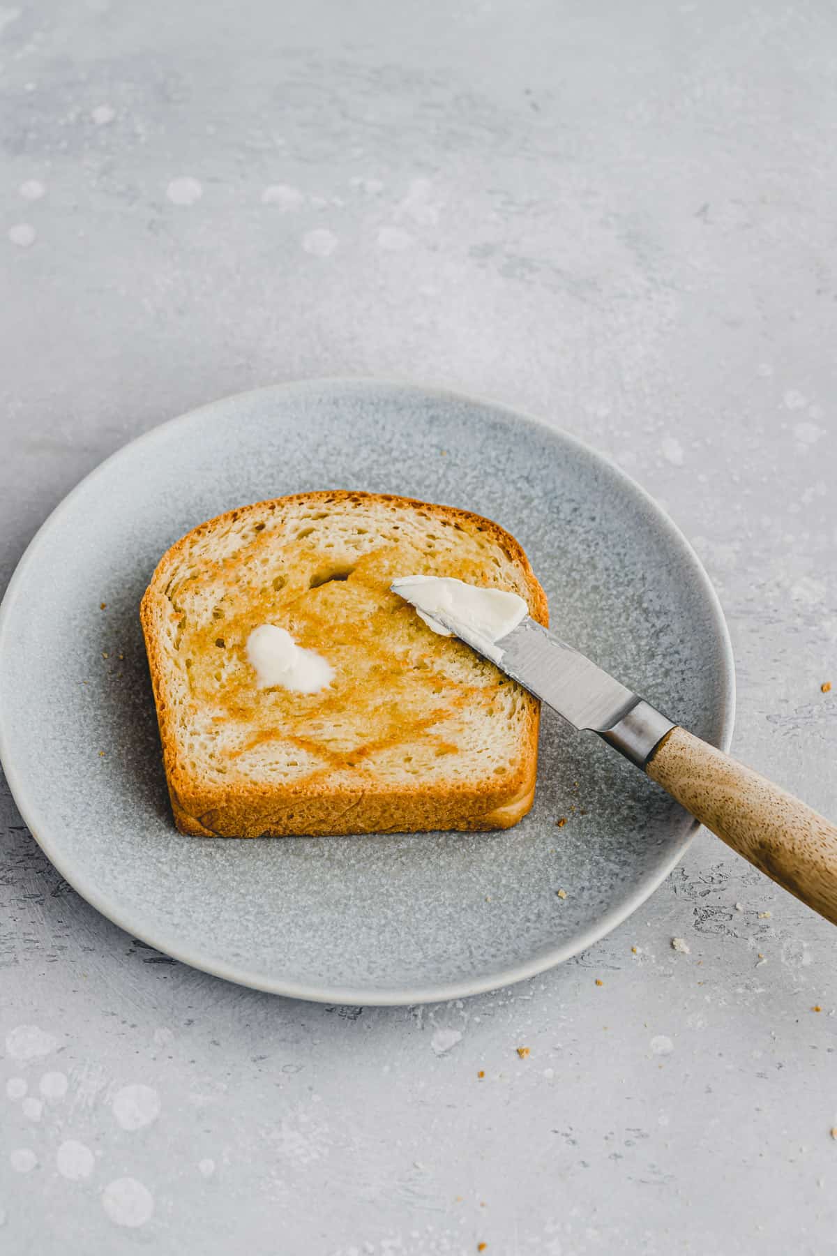 eine scheibe toastbrot auf einem teller mit margarine