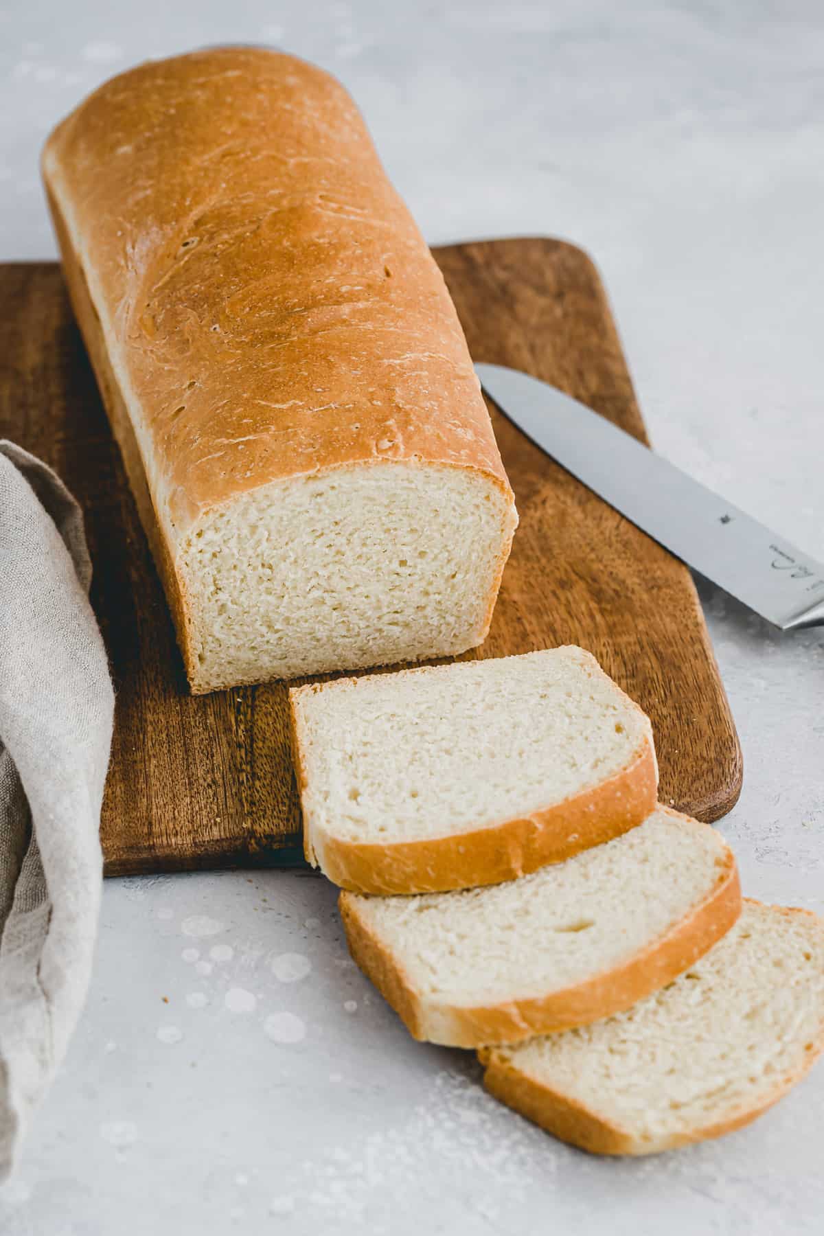 angeschnittenes toastbrot auf einem holzbrett