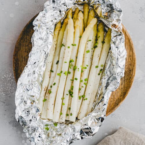 weisser spargel in alufolie mit schnittlauch dekoriert