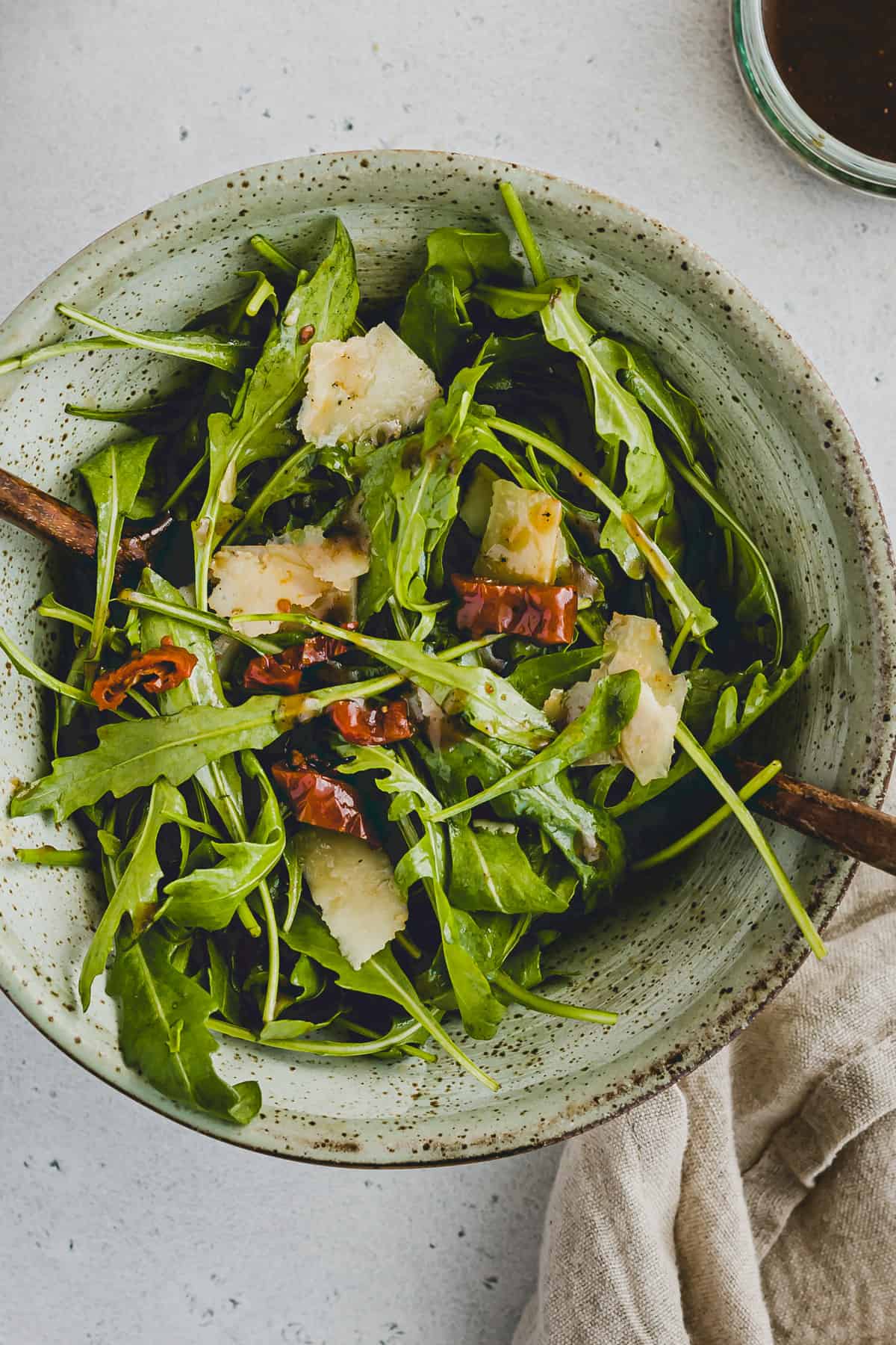 rucolasalat mit parmesan und getrockneten tomaten in einer schüssel