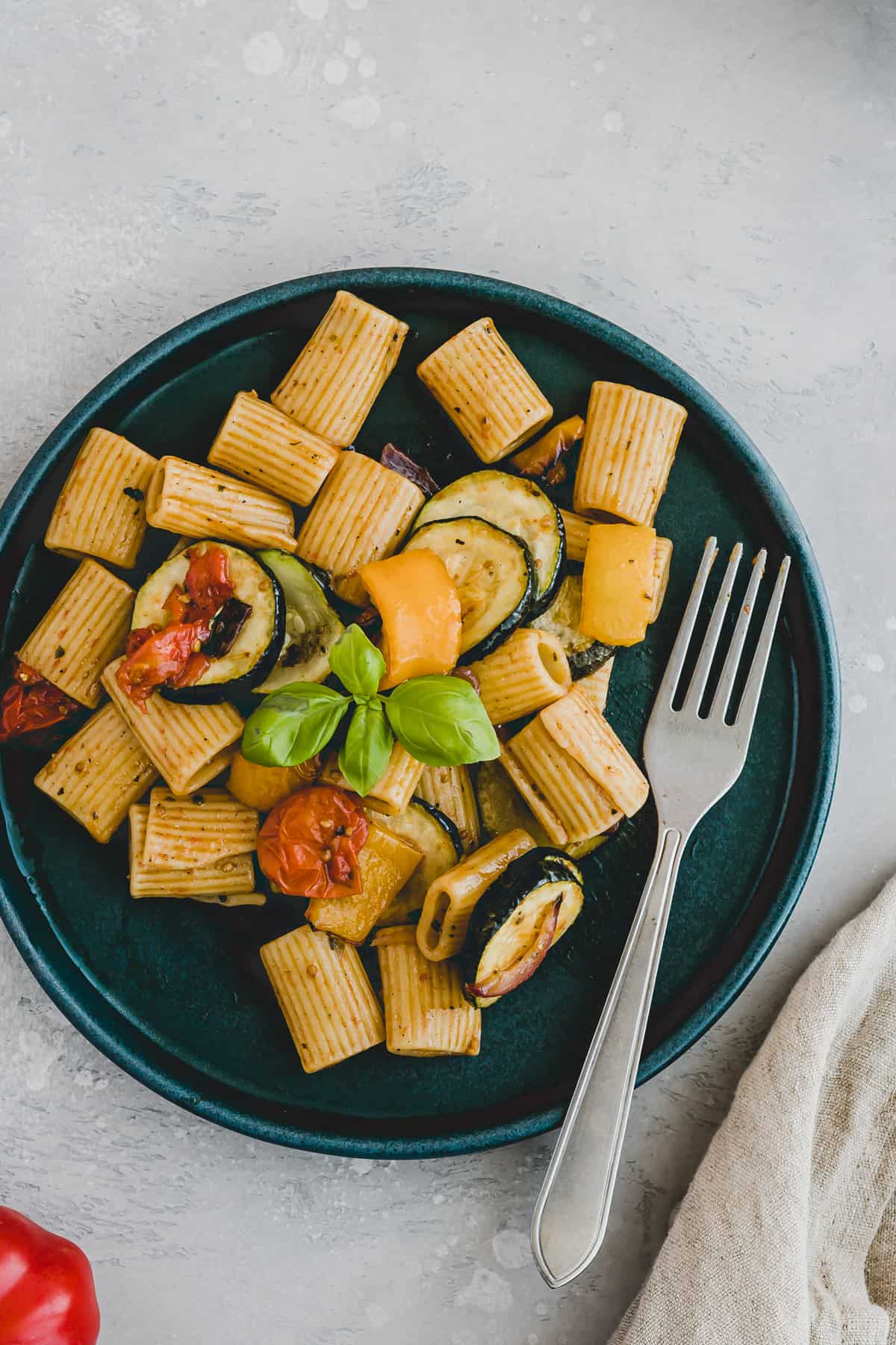 nudelsalat vegetarisch mit backofen gemüse auf einem blauen teller