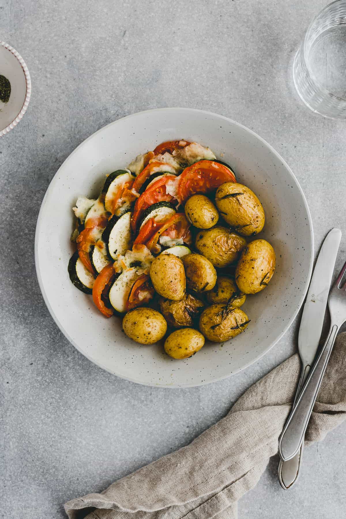 zucchini tomaten gratin serviert mit ofenkartoffeln